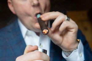 man lighting a cigar